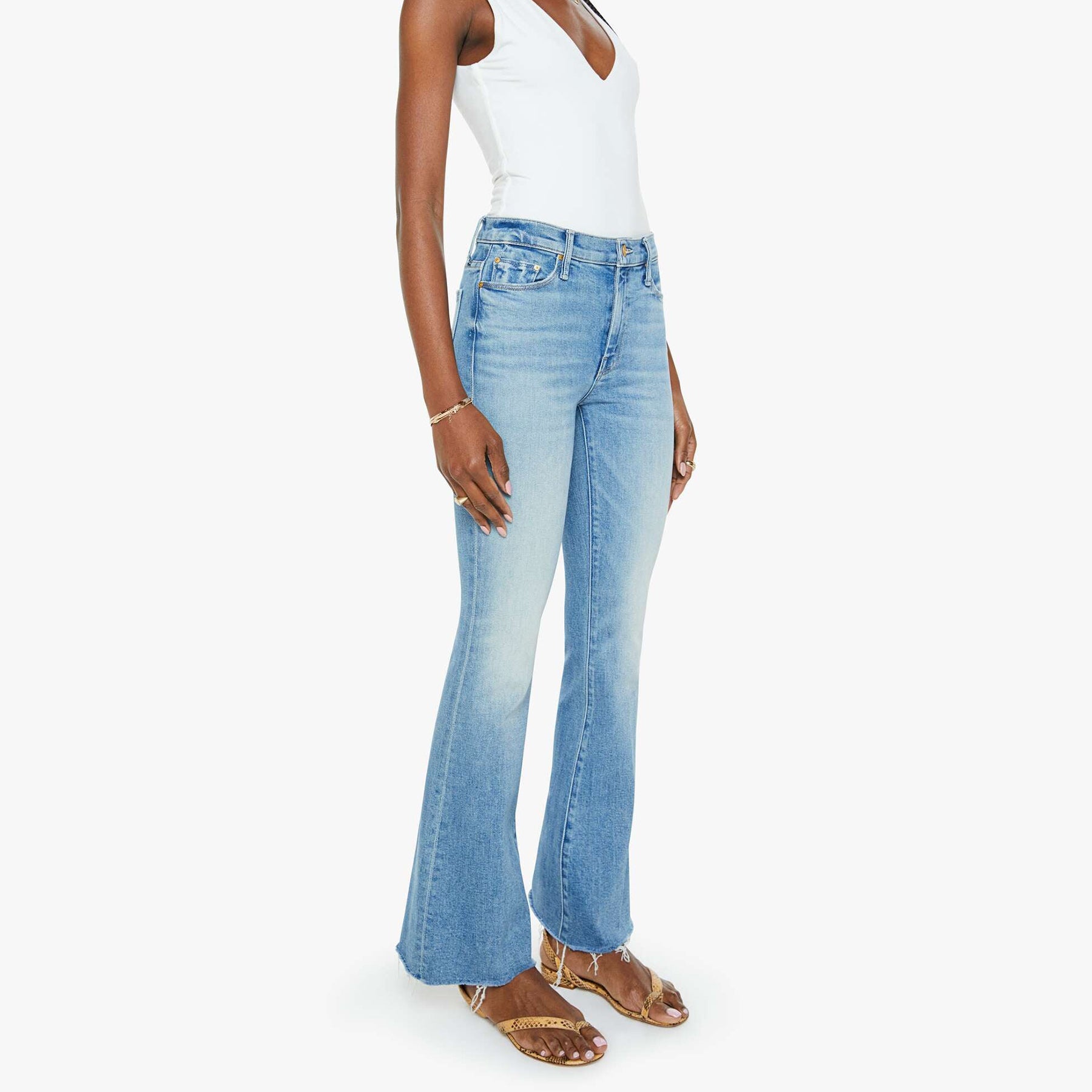 Model wearing mid-rise flare jeans with frayed hem, whiskering, and fading in a light wash, showcasing a stylish look.