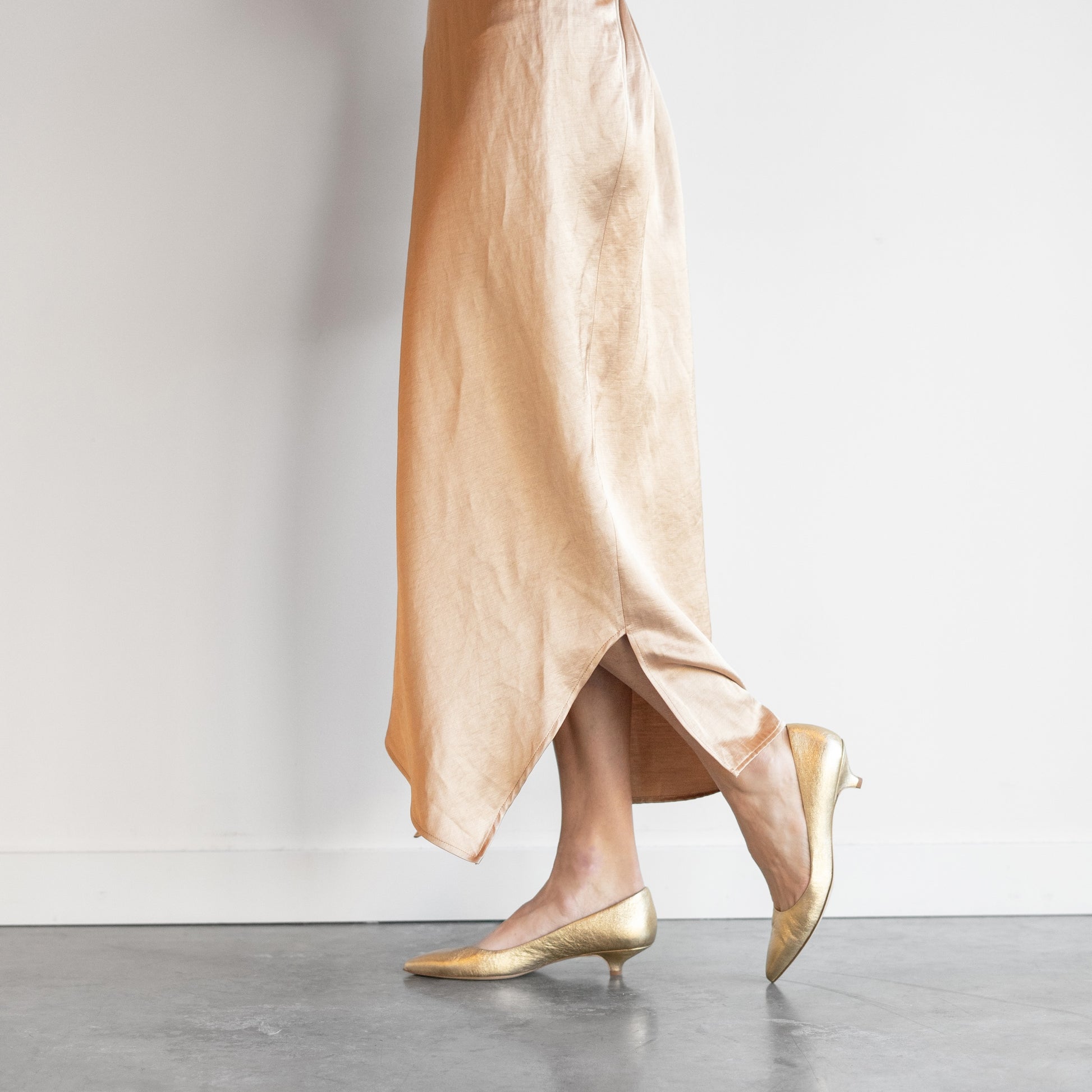 Kitty Point Heel in Warm Gold, featuring pointed toe and kitten heel, paired with a chic outfit, handcrafted in Italy.