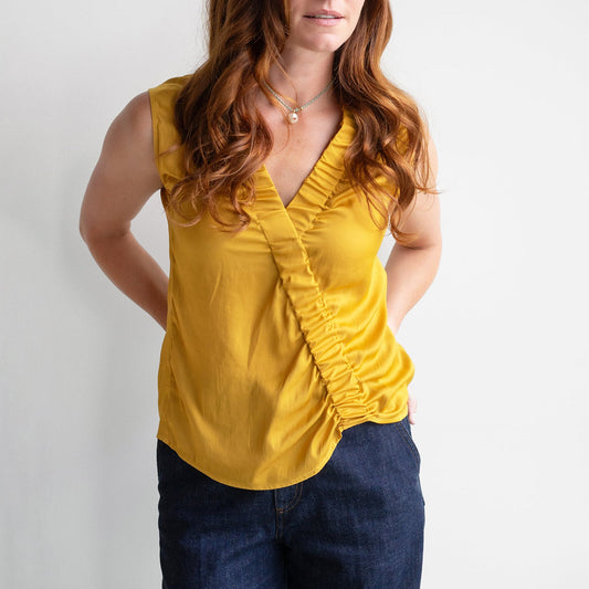 Elise Sleeveless Top in Sunflower, a satin V-neck blouse with ruched gathers, perfect for casual or dressy occasions.
