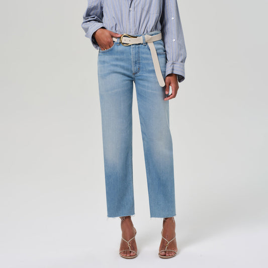 High-rise straight leg jeans in soft stretch denim, cropped with unfinished hem, paired with a stylish belt.