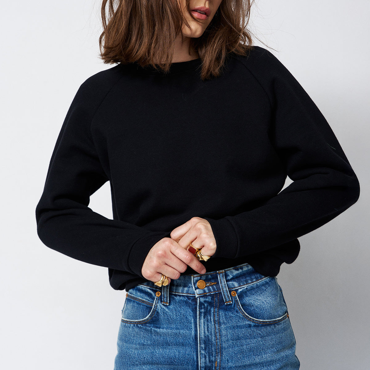 Model wearing a Baggy Crew Sweatshirt in Black with high-waisted jeans and stylish accessories.