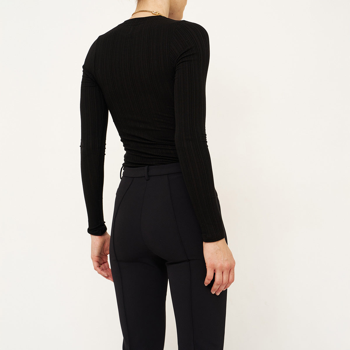 Long Rib Tee in Black displayed from the back, featuring a slim fit and smooth ribbed texture.