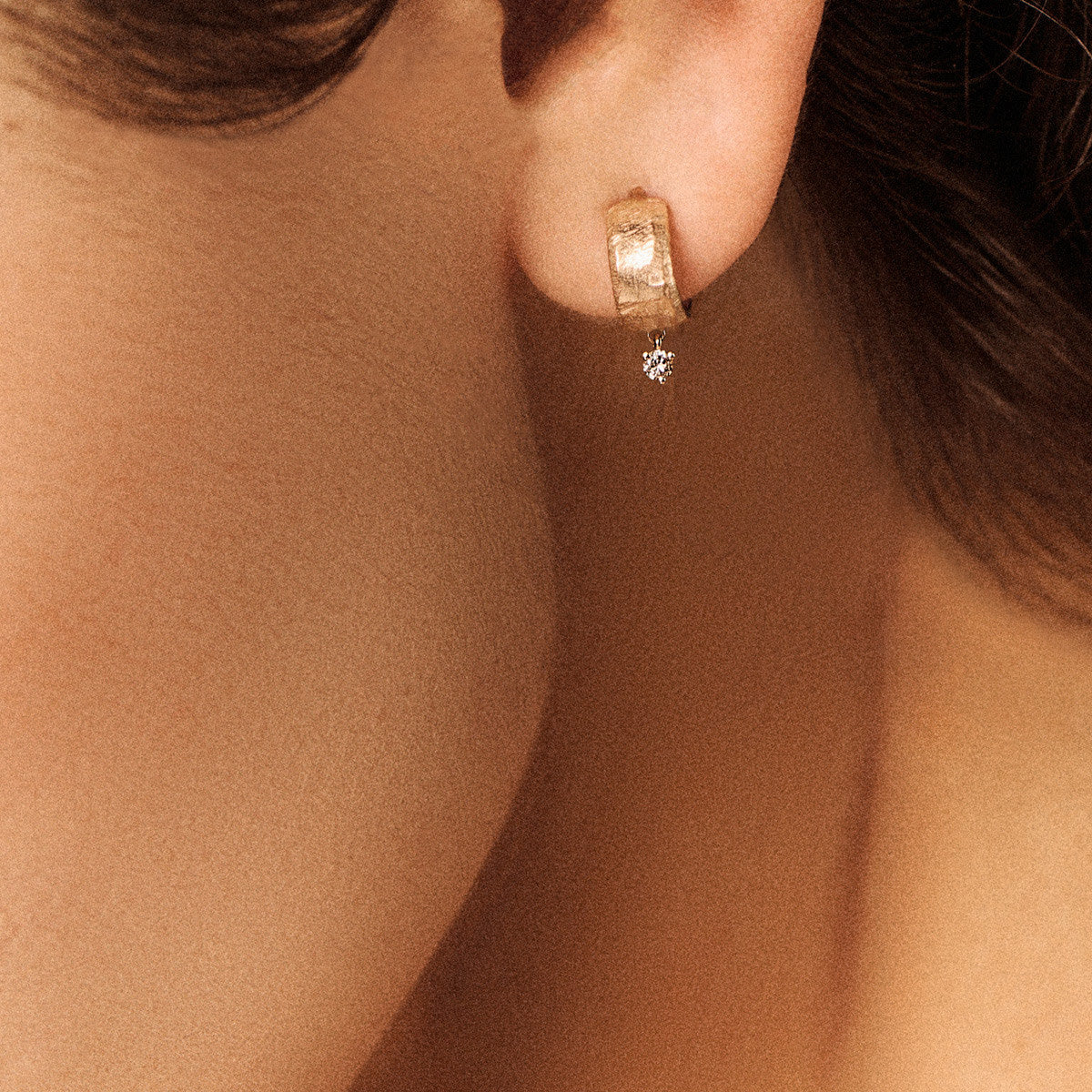 Gaby No.1 Earrings in 9K Yellow Gold displayed on a model's ear with a diamond accent.