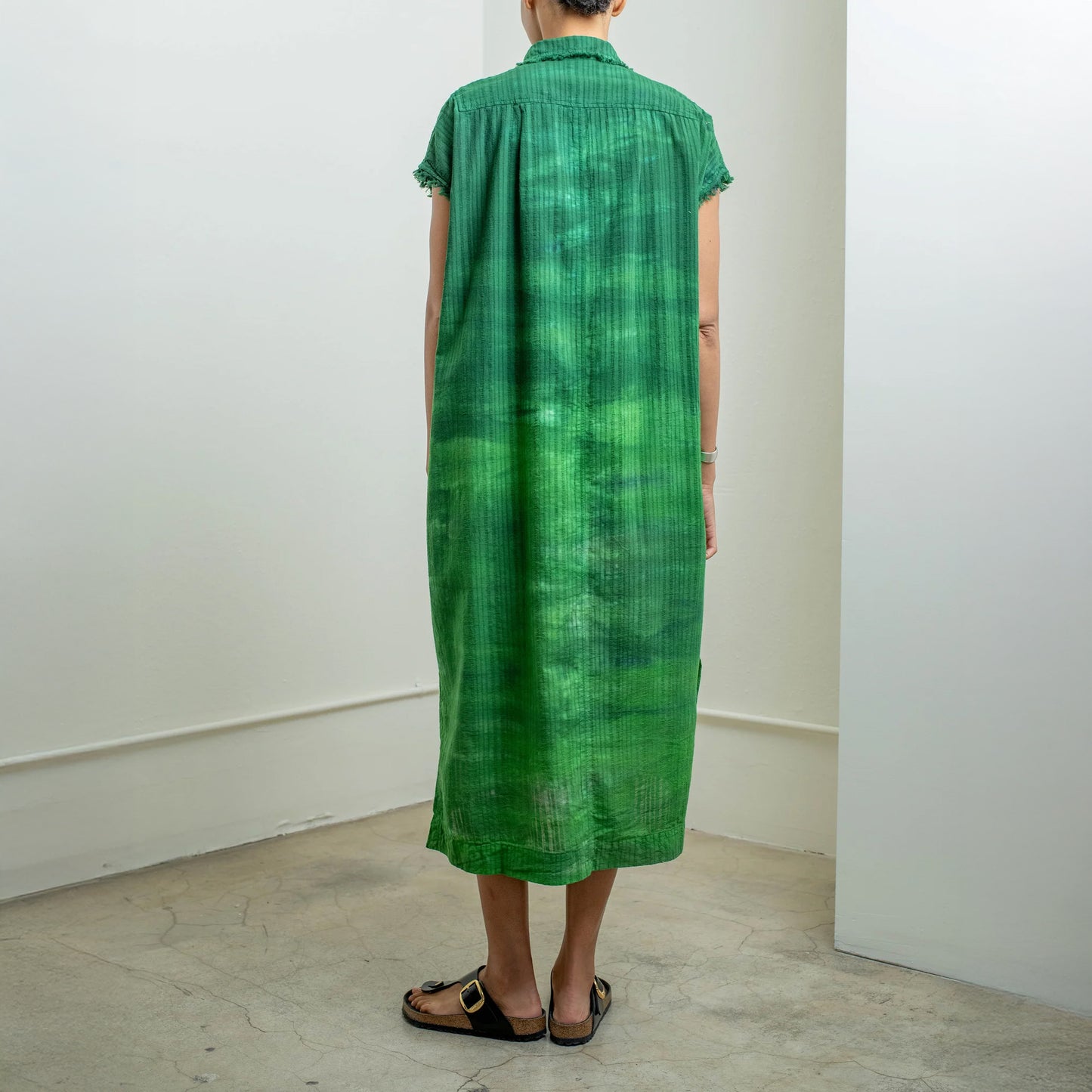 Back view of a green rainbow tie-dye caftan dress with a relaxed fit and fringed sleeves, showcasing unique fabric pattern.