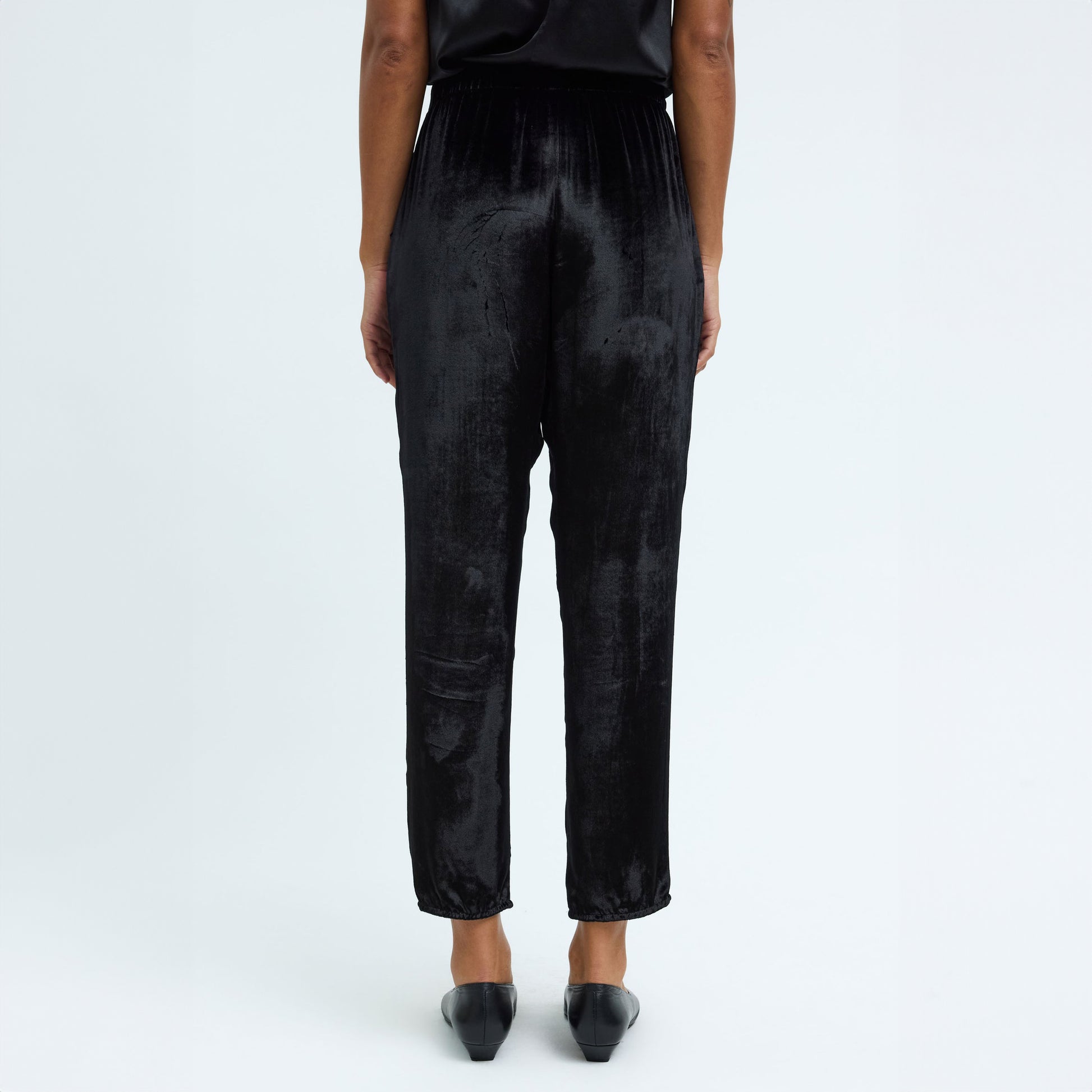 Back view of Black Velvet Fez Pant with elastic waistband and side pockets, perfect for versatile styling.