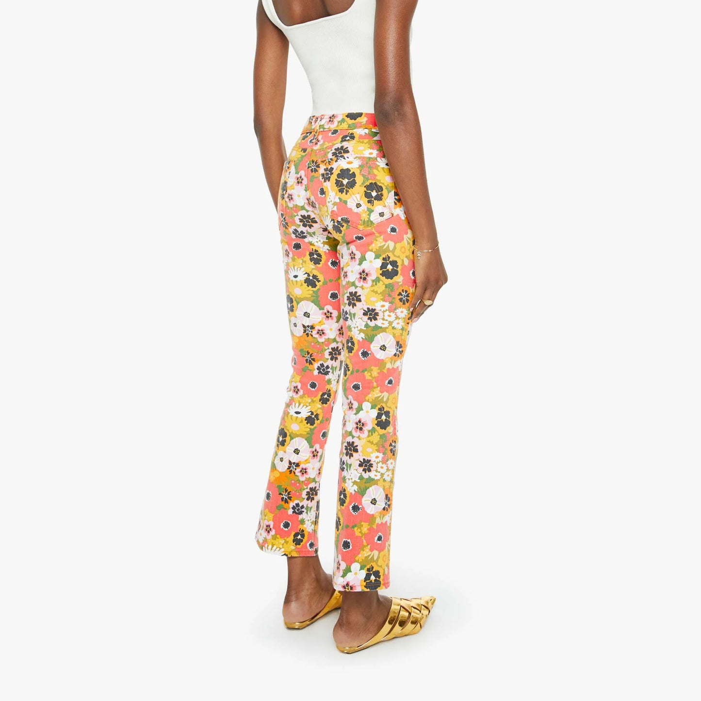 Model showcasing mid-rise flared jeans with vibrant floral print from behind, perfect for a stylish casual look.