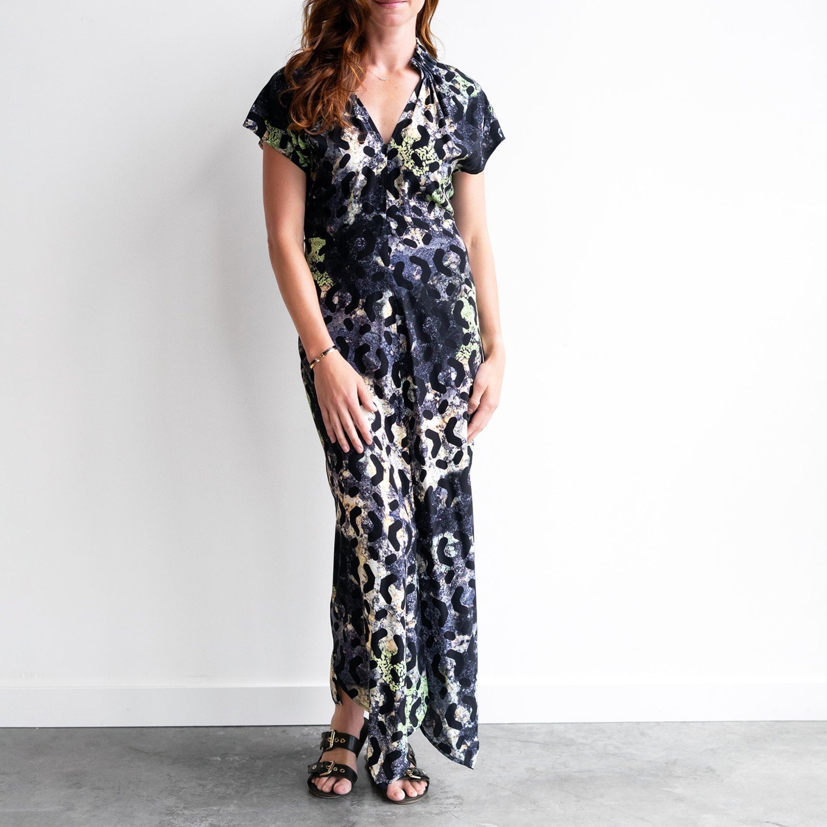 Model wearing a stylish floral print dress with V-neckline and asymmetrical hem, showcasing elegance and modern design.