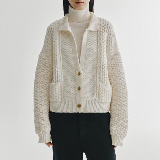 Becs Cardigan in Cream displayed on model, featuring a relaxed silhouette and cable knit design.