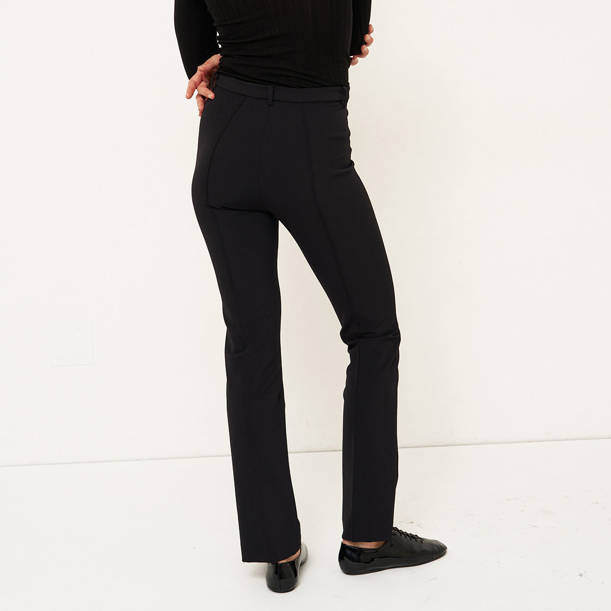 The Riding Pant in Black showcased from the back, featuring a slim fit and tailored design.