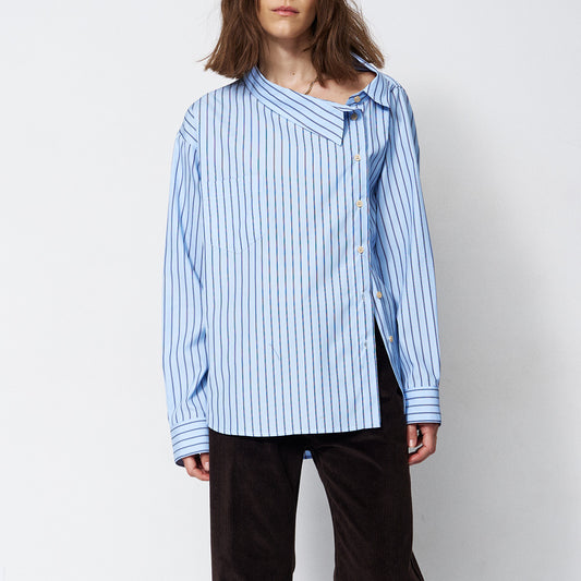 The Asymmetry Shirt in Cornflower Stripe, featuring an asymmetric front and collar in blue and white stripes.