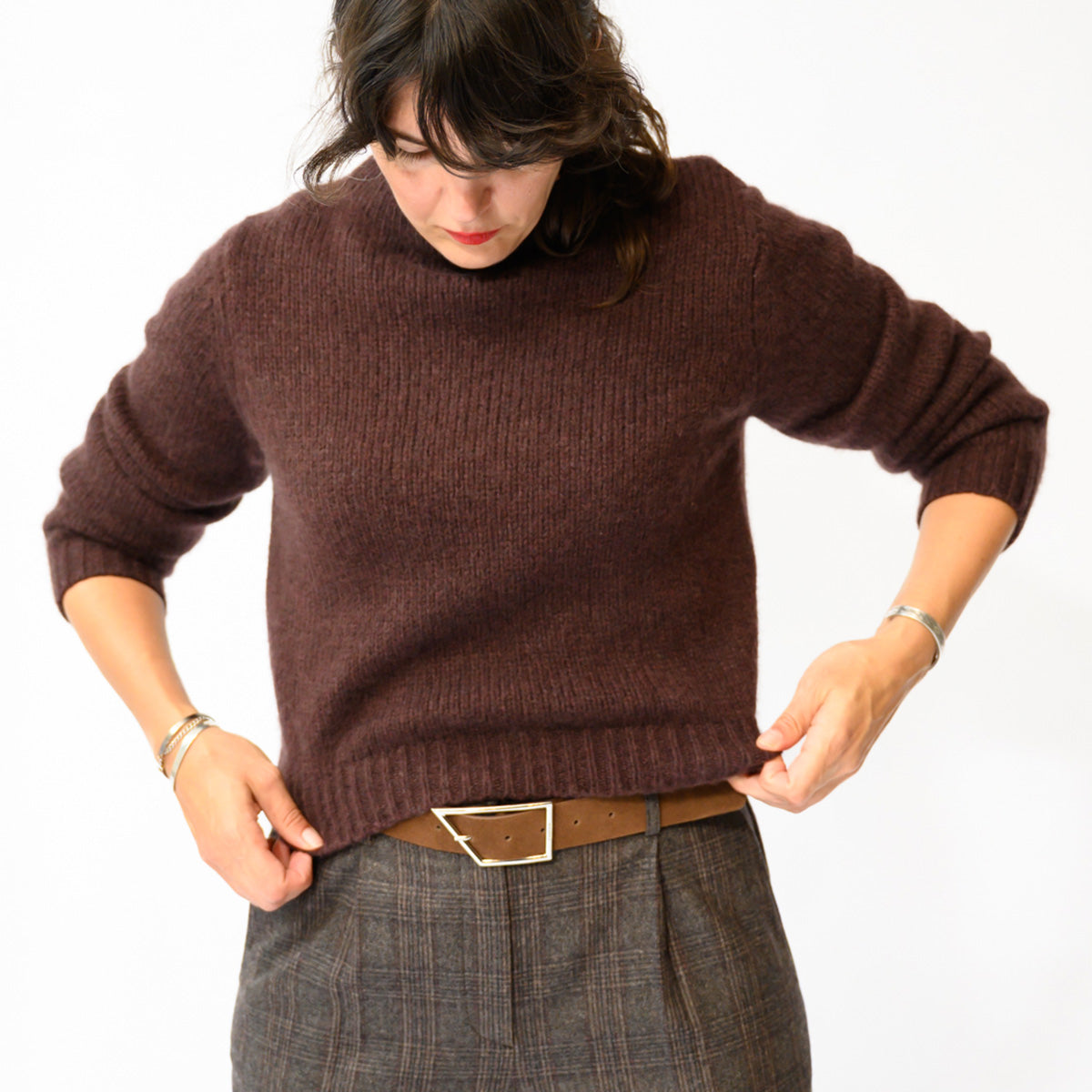 Maire Sweater in Red Umber worn with high-waisted pants, featuring blouson sleeves and ribbed cuffs.