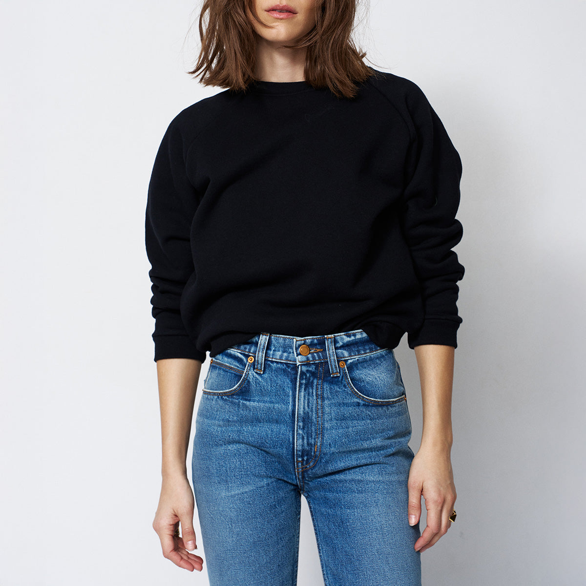 Baggy Crew Sweatshirt in Black worn with blue jeans, showcasing a casual and comfortable style.