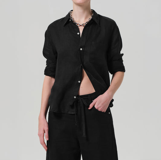 Stylish model wearing the Kayla Shrunken Shirt in Black, featuring a tailored fit and high-low hem, made from 100% linen.