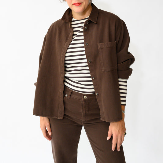 Arizona Shirt in Ciocco shown in a close-up view, paired with a striped top, highlighting a rich brown color and casual style.