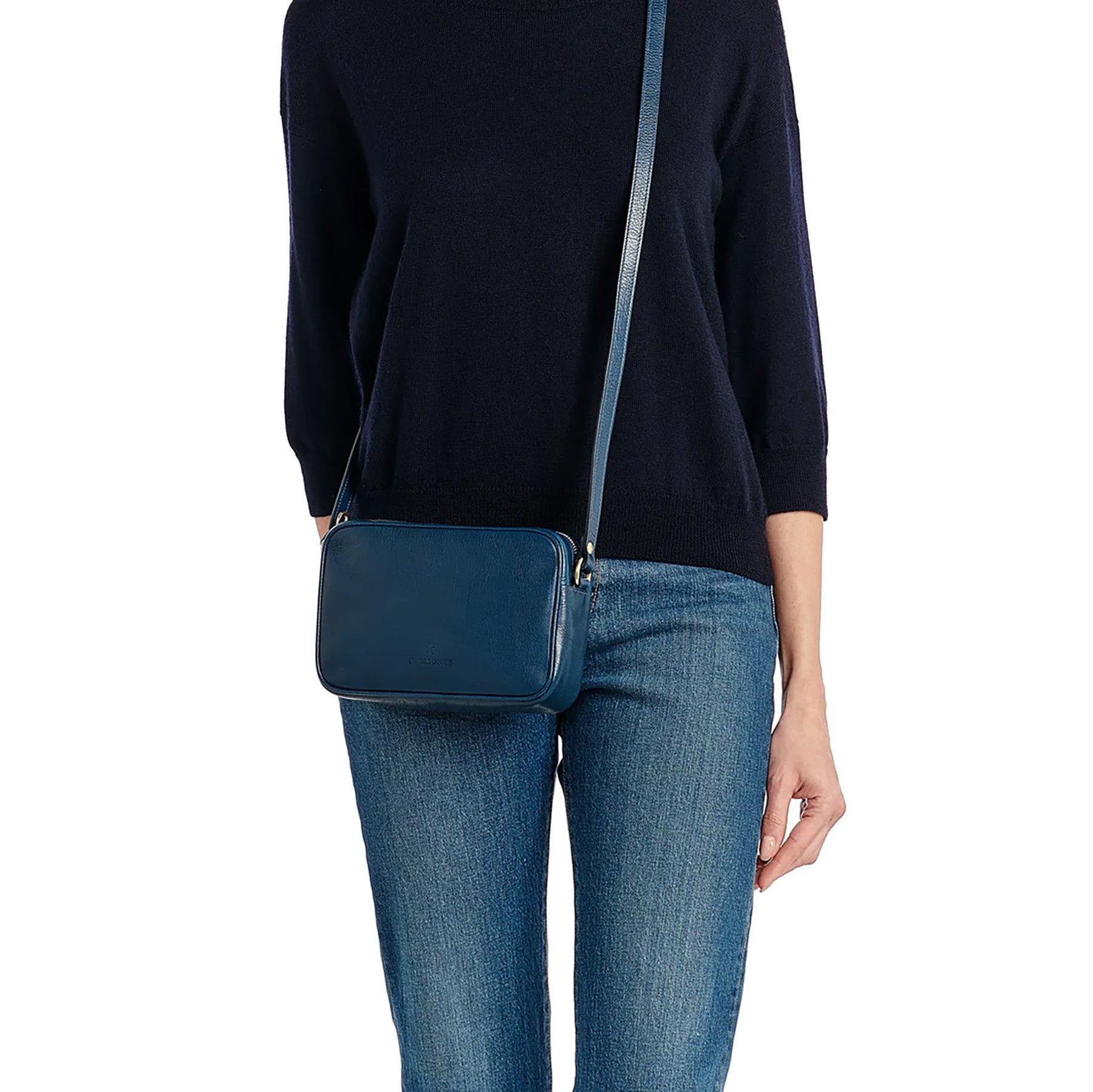 Oliveta Crossbody Bag in Blue, handcrafted vegetable tanned leather, stylish and compact design, worn with casual attire.