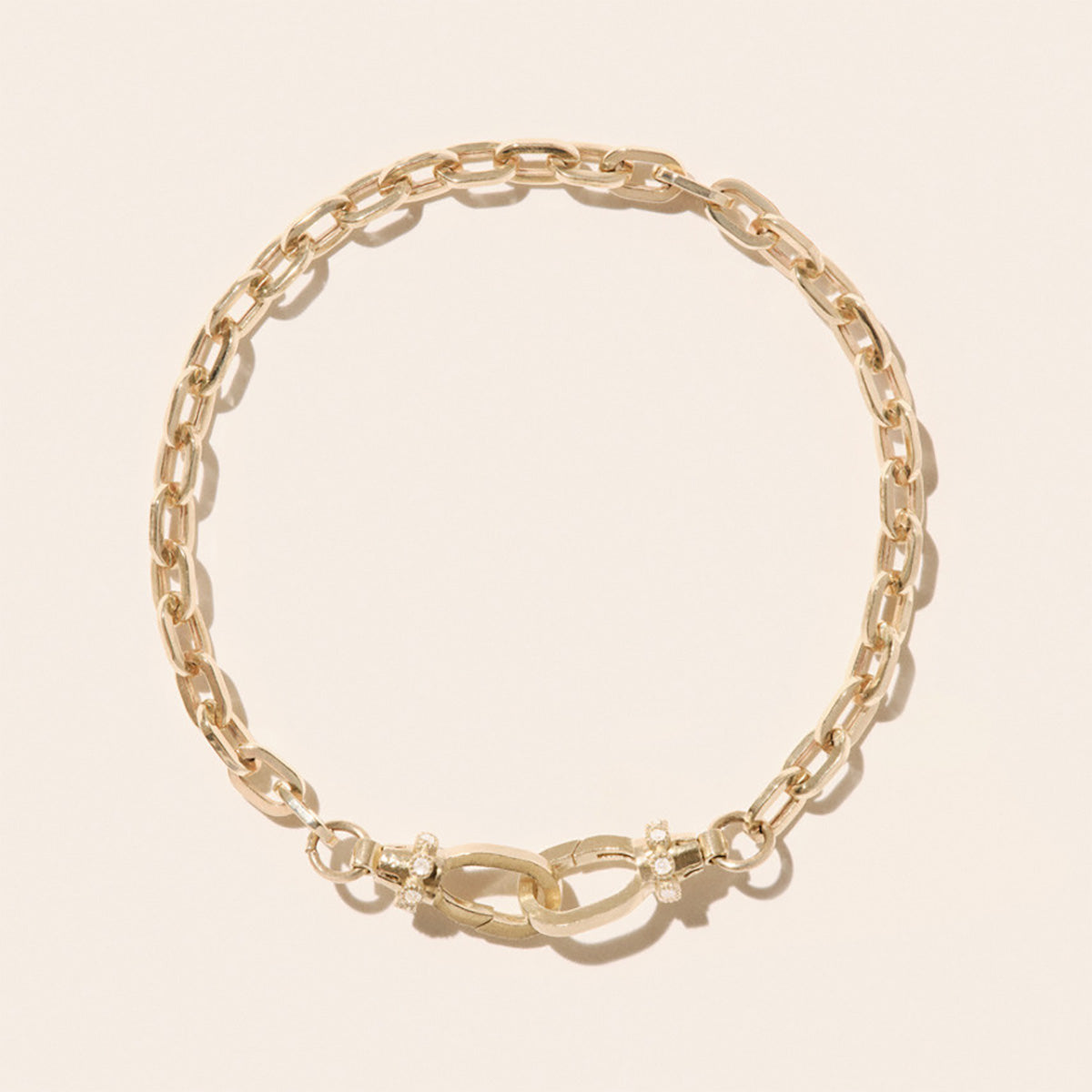 May Bracelet in 9K Yellow Gold featuring interlocking lock clasps and diamond accents.