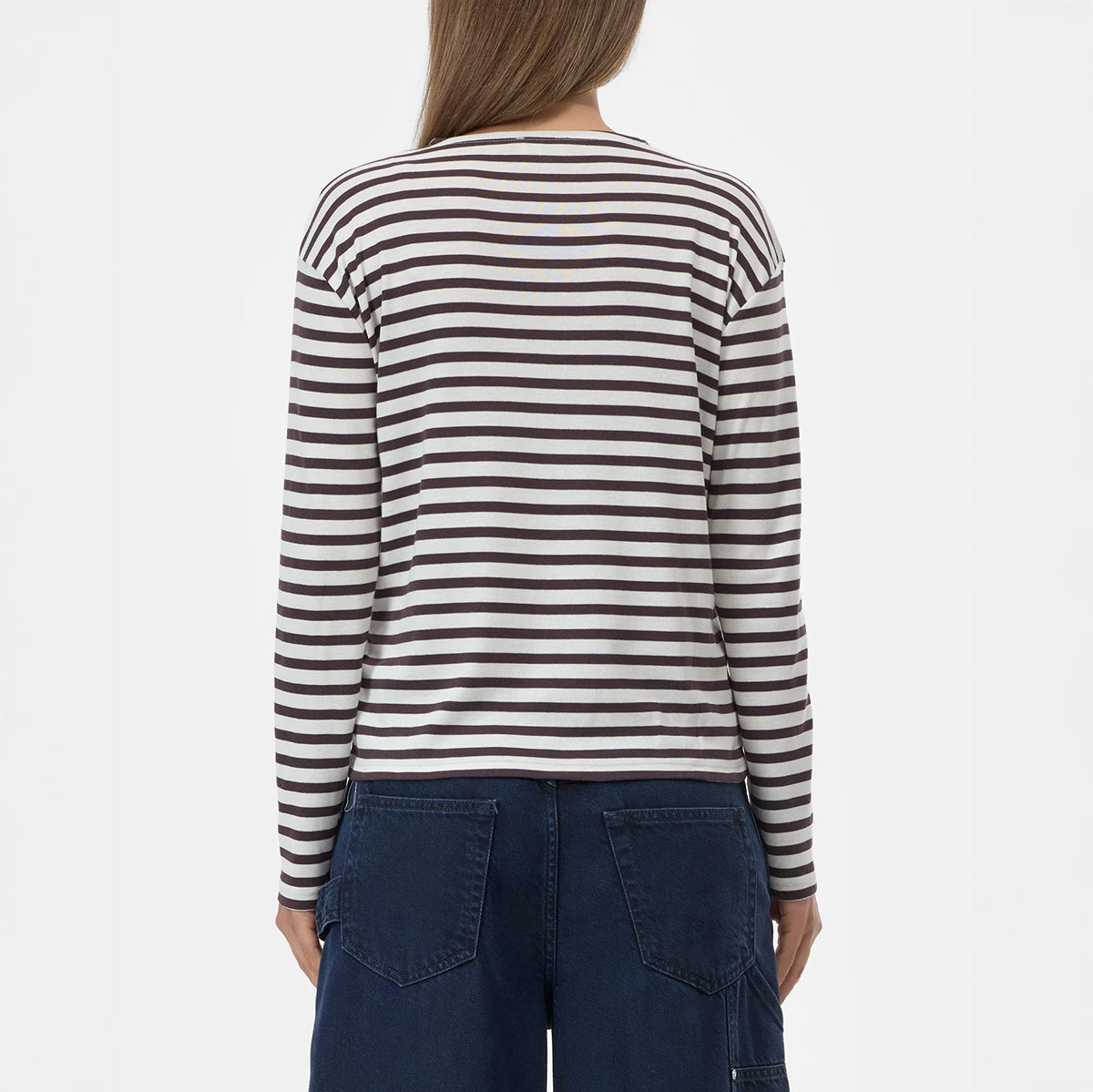 Back view of a woman wearing a striped Basic Longsleeve in Cinder Brown, showcasing its relaxed fit and crew neckline.
