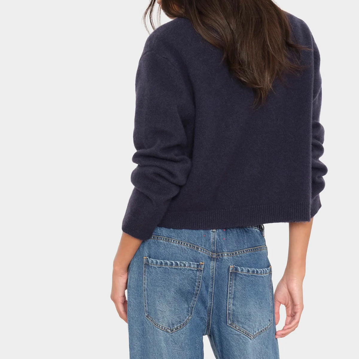Bevyn Cardigan in Midnight Blue worn with jeans, showing slightly cropped design and point collar.