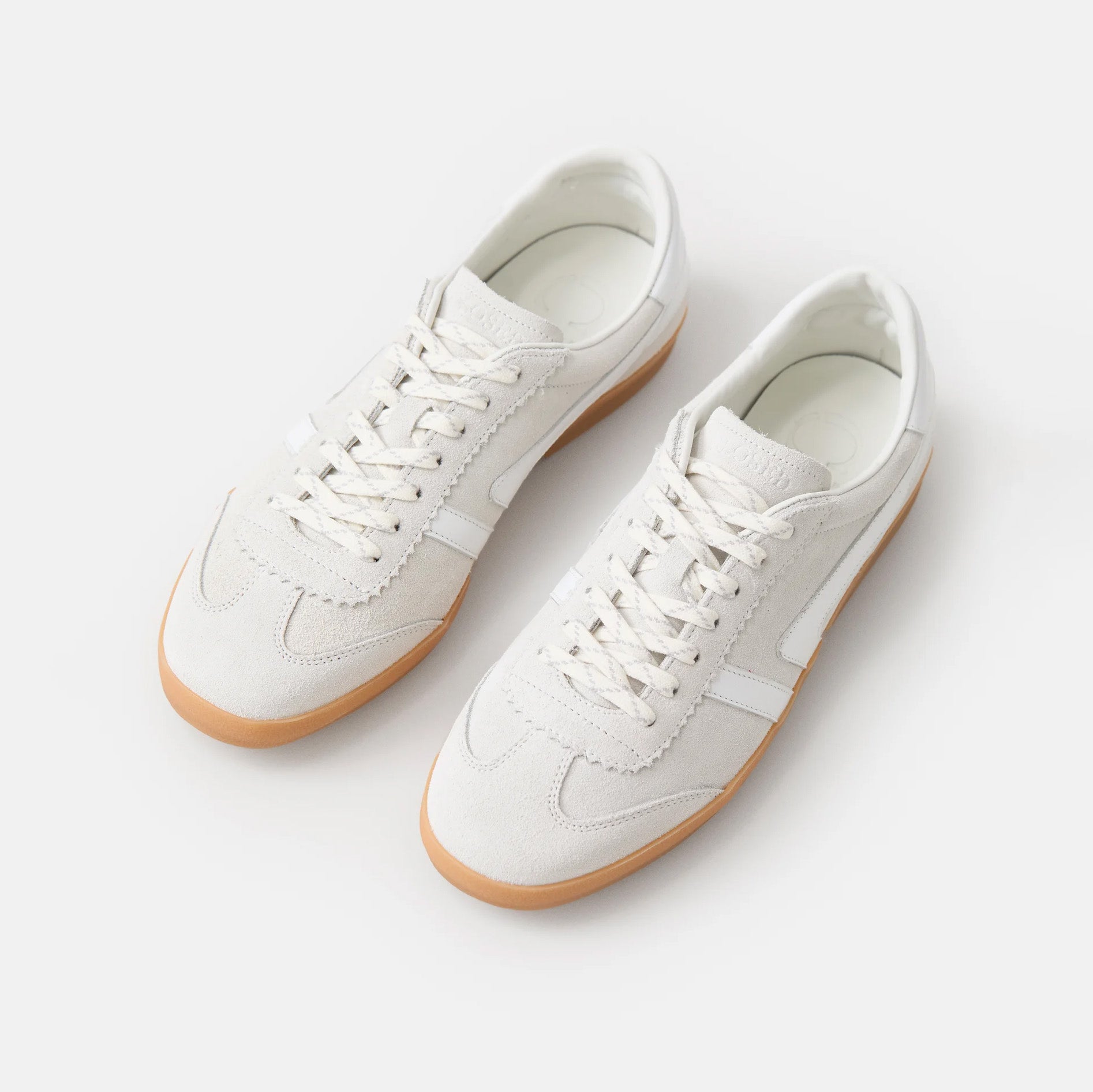 Slim white low-top sneakers in Italian nappa leather with suede accents and rubber sole.