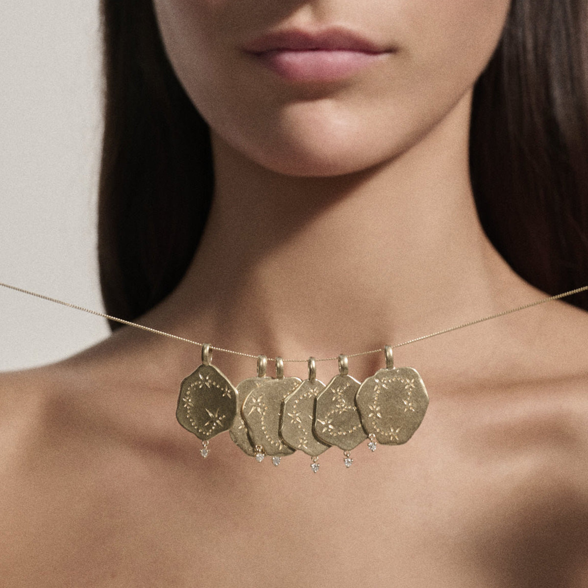 Taurus Pendant in 9K Yellow Gold showcased on model, featuring diamond accents and constellation engravings.