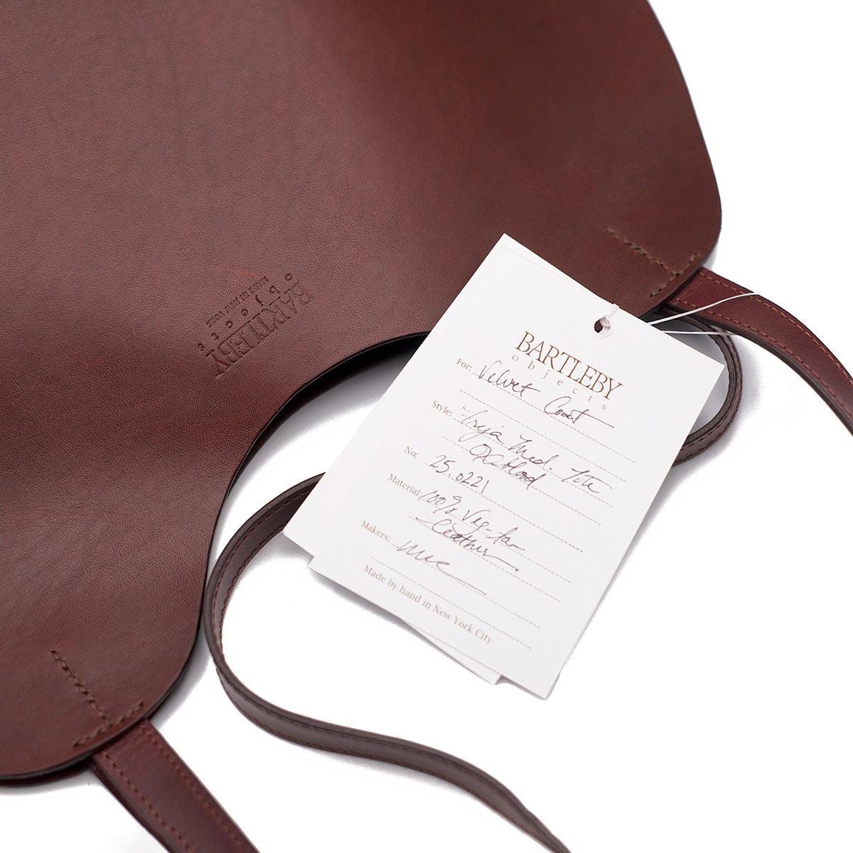 Freja Tote in Oxblood leather, featuring a hand-stitched label and flat leather straps, made in NYC.