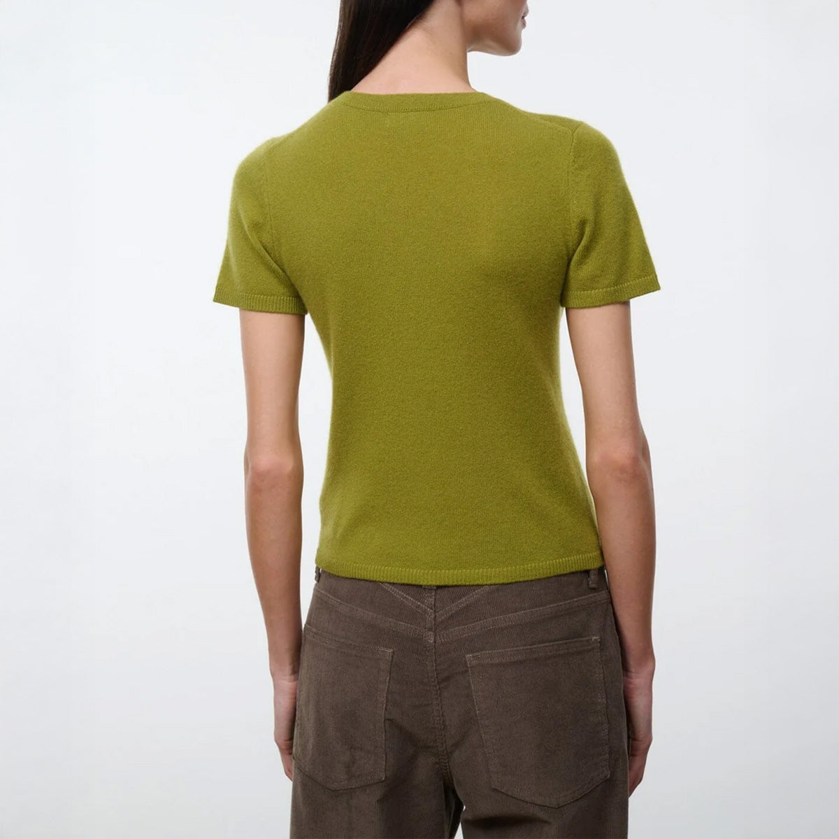 Back view of a model wearing an Easy Cashmere Tee in Pear with short sleeves and a fitted silhouette.