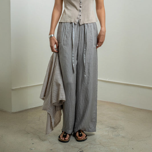 Model wearing Broadway Pant in Dusty Gray, wide-leg elastic waist with silk ribbon drawstring and crinkle fabric.