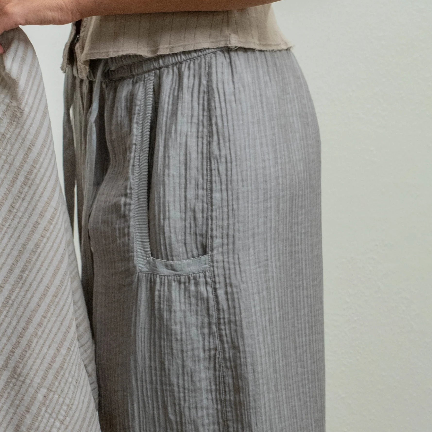 Side view of wide-leg Broadway Pant in Dusty Gray, showcasing textured crinkle cotton fabric and dropped pockets.