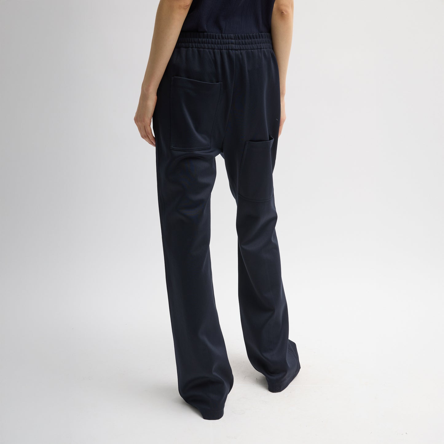 Elastic waist trouser with functional drawstring and oversize back pocket. Snap detail at hem allows for adjustment of pant length. Active knit fabric: 59% polyamide, 38% cotton, 3% elastane Inseam: 33" Front rise: 12.75" Waist: 31" (size S) T000AK3312