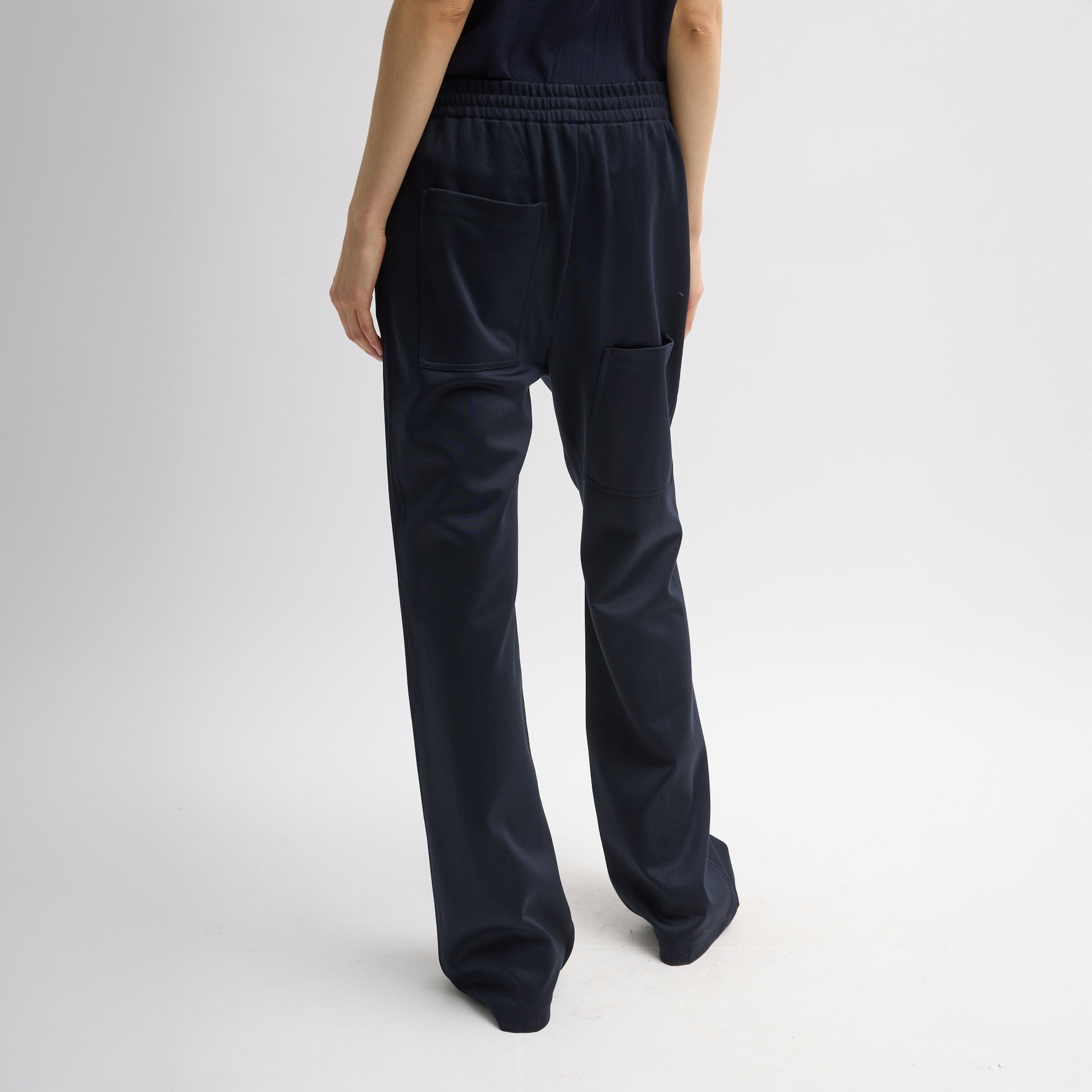 Elastic waist trouser with functional drawstring and oversize back pocket. Snap detail at hem allows for adjustment of pant length. Active knit fabric: 59% polyamide, 38% cotton, 3% elastane Inseam: 33" Front rise: 12.75" Waist: 31" (size S) T000AK3312