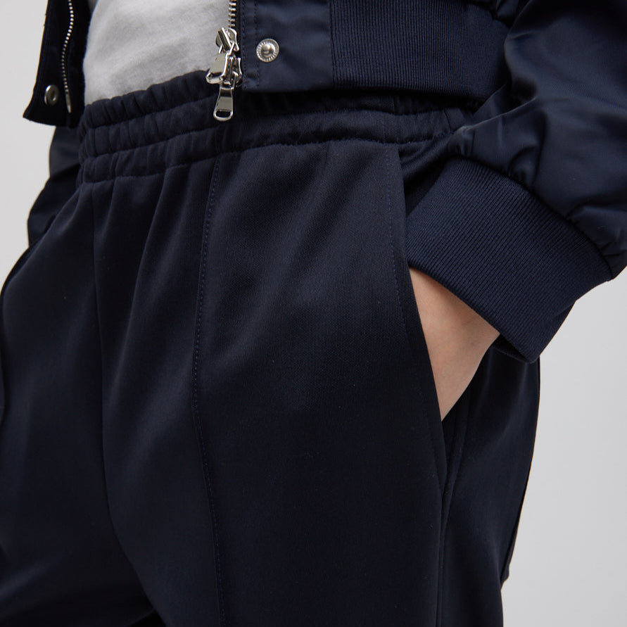 Elastic waist trouser with functional drawstring and oversize back pocket. Snap detail at hem allows for adjustment of pant length. Active knit fabric: 59% polyamide, 38% cotton, 3% elastane Inseam: 33" Front rise: 12.75" Waist: 31" (size S) T000AK3312