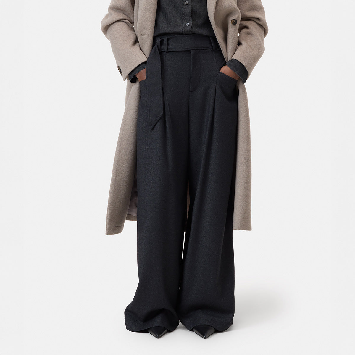 Wes Pant in Black Melange featuring wide leg and belt detail, front view with stylish coat and shoes.