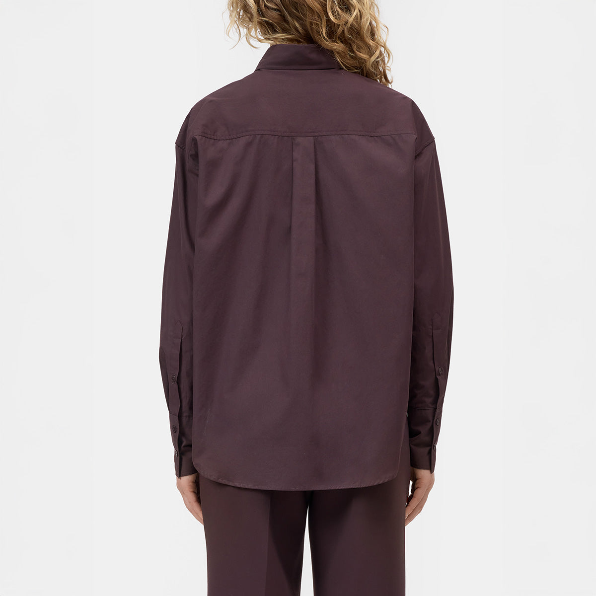Back view of a model wearing a Wrap Shirt in Cinder Brown, showing rounded hem and button details.